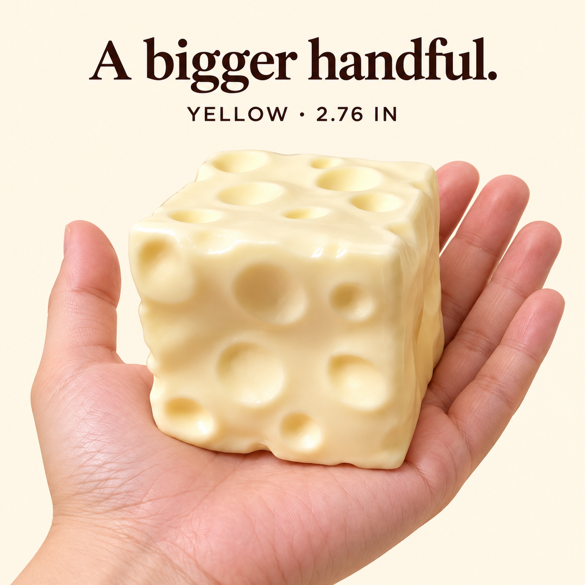 Large 2.76 inch yellow moldable cheese cube squishy on an adult palm